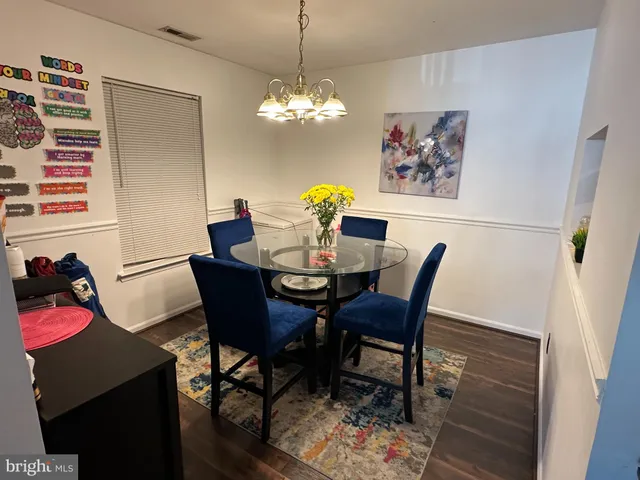 a dining room with furniture potted plants and wooden floor