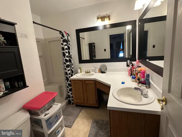 a bathroom with a sink vanity mirror and toilet