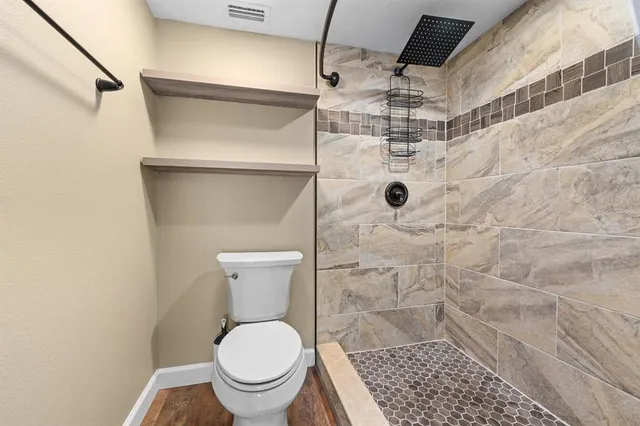 a bathroom with a toilet and a shower