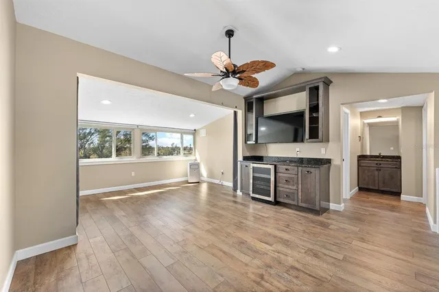 a view of an empty room with a window and a kitchen