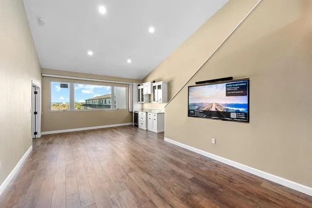 a view of empty room with wooden floor and window