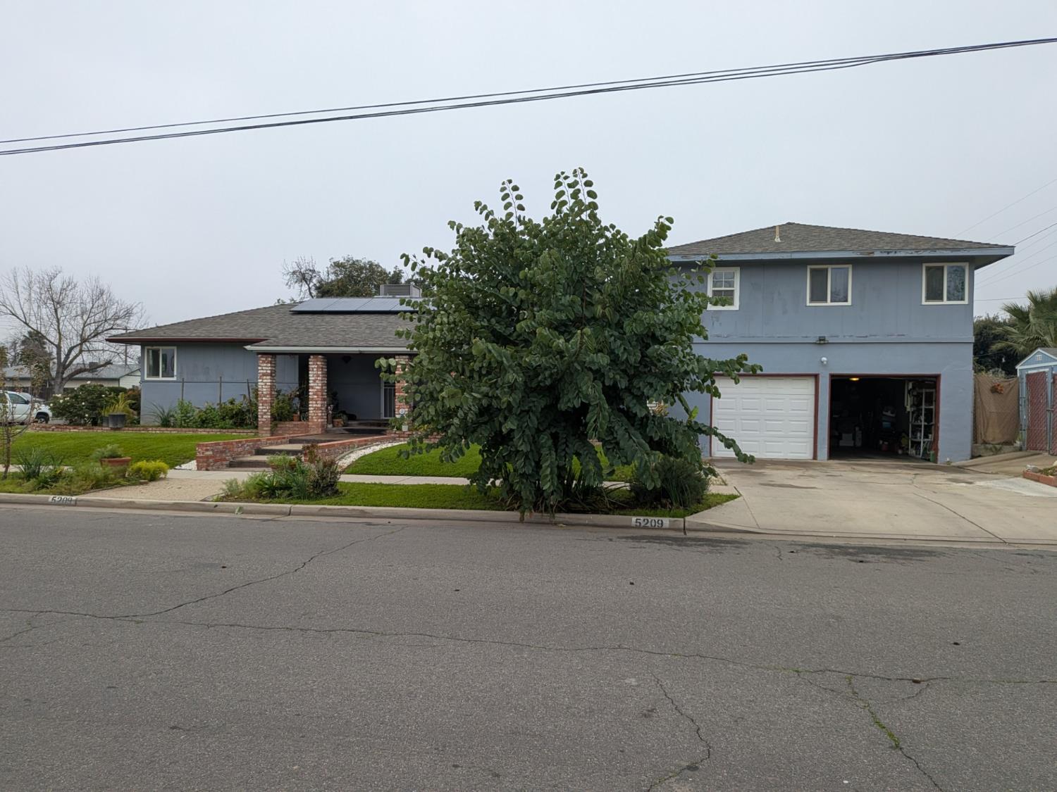 5209 North Angus Street Fresno, CA 93710 - Photo 7 of 33 a view of a house with a small yard and palm trees