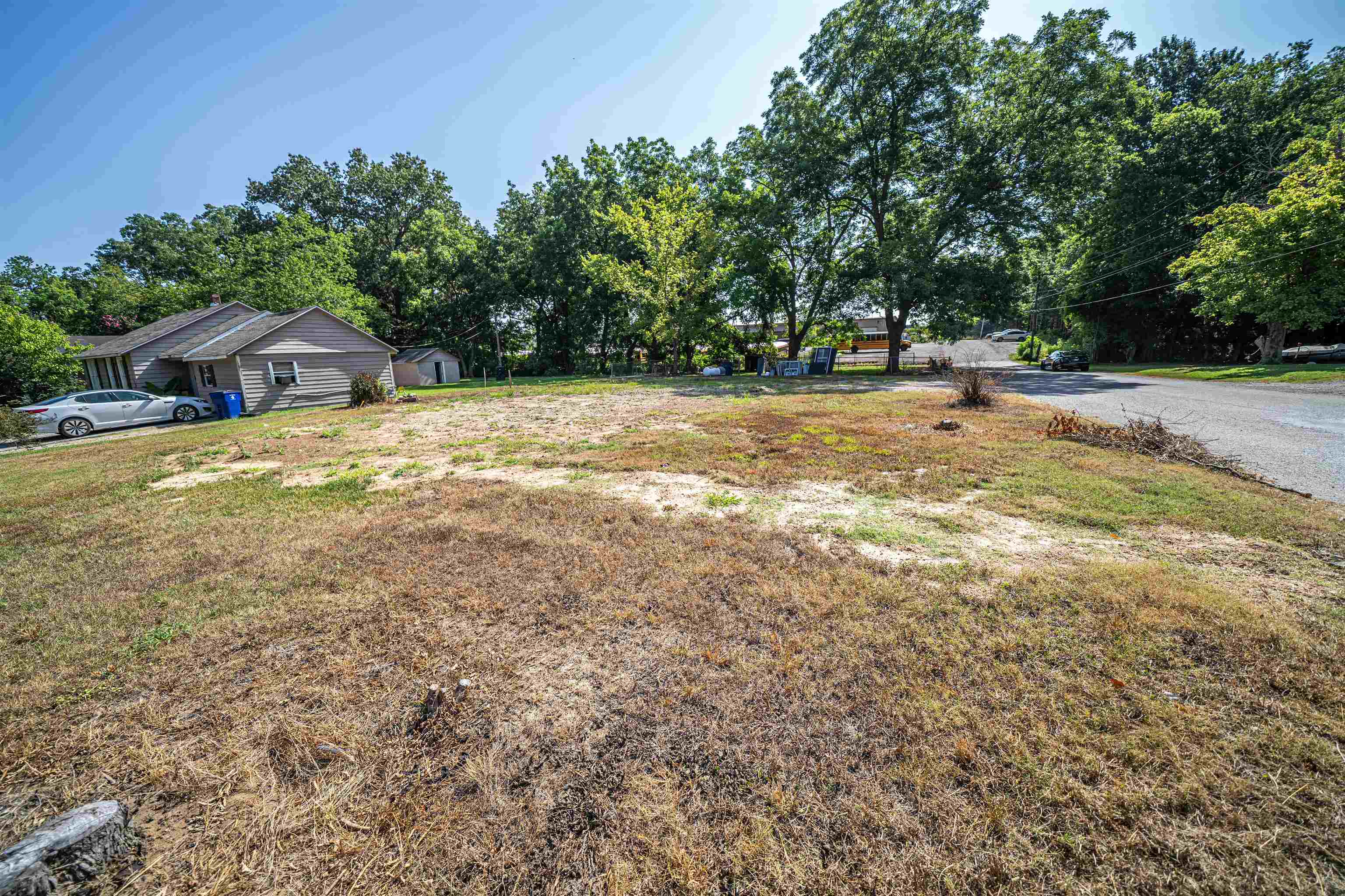 a view of yard with swimming pool and trees in the background