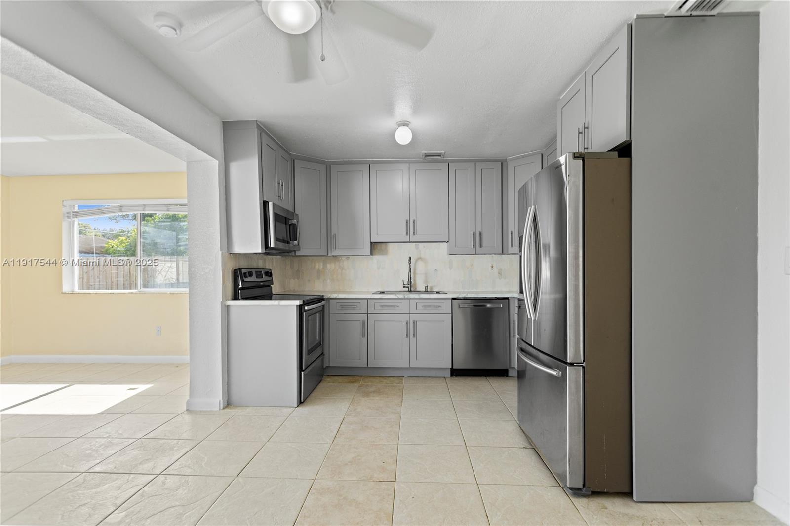 1831 Southwest 97th Terrace Miramar, FL 33025 - Photo 18 of 61 a kitchen with a refrigerator a sink and a stove top oven