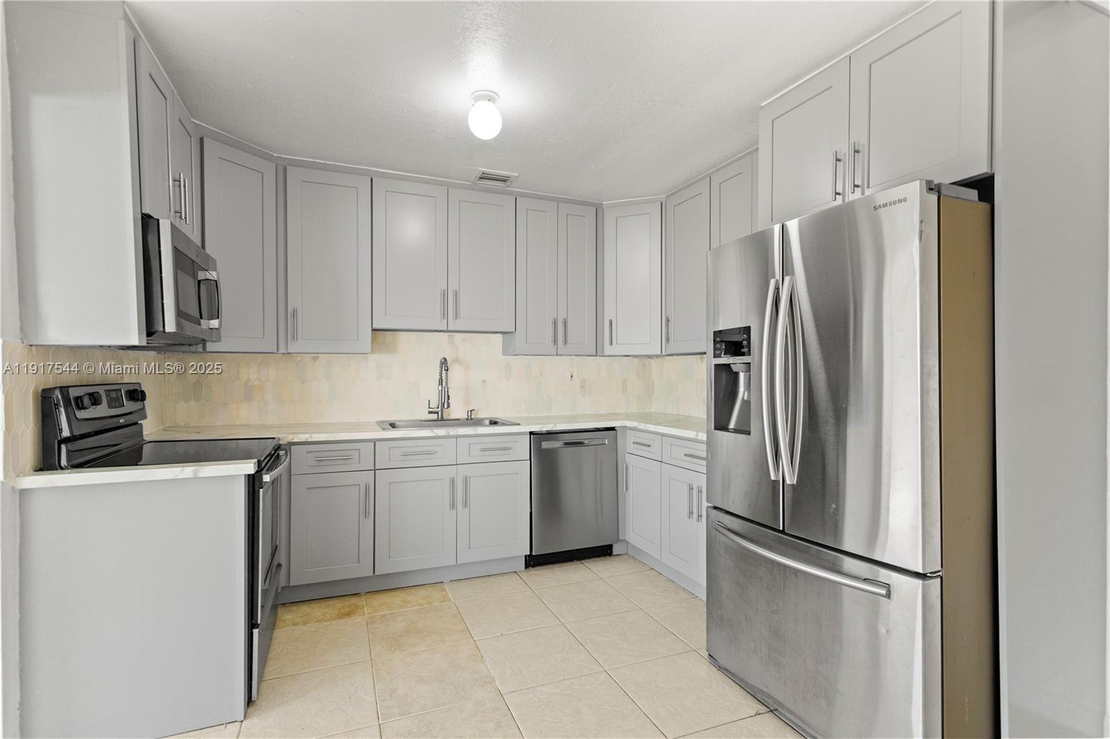1831 Southwest 97th Terrace Miramar, FL 33025 - Photo 20 of 61 a kitchen with stainless steel appliances granite countertop a refrigerator and a stove