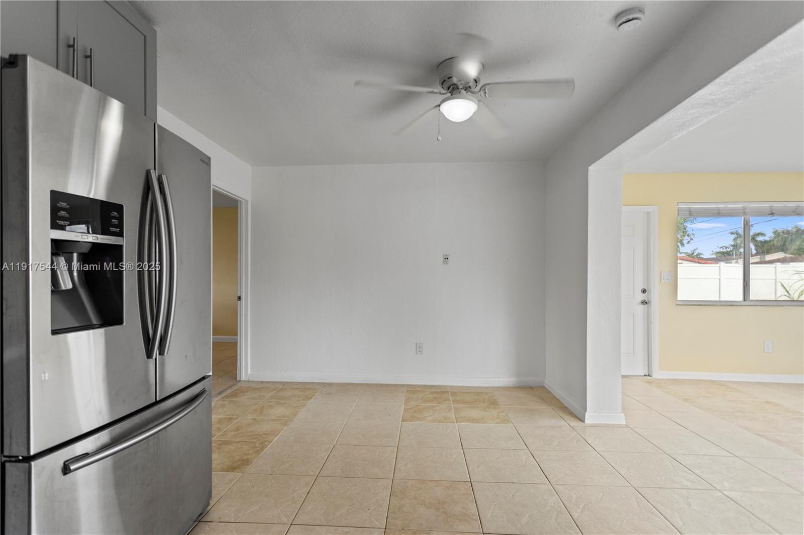 1831 Southwest 97th Terrace Miramar, FL 33025 - Photo 23 of 61 a view of a refrigerator in kitchen and an empty room with wooden floor