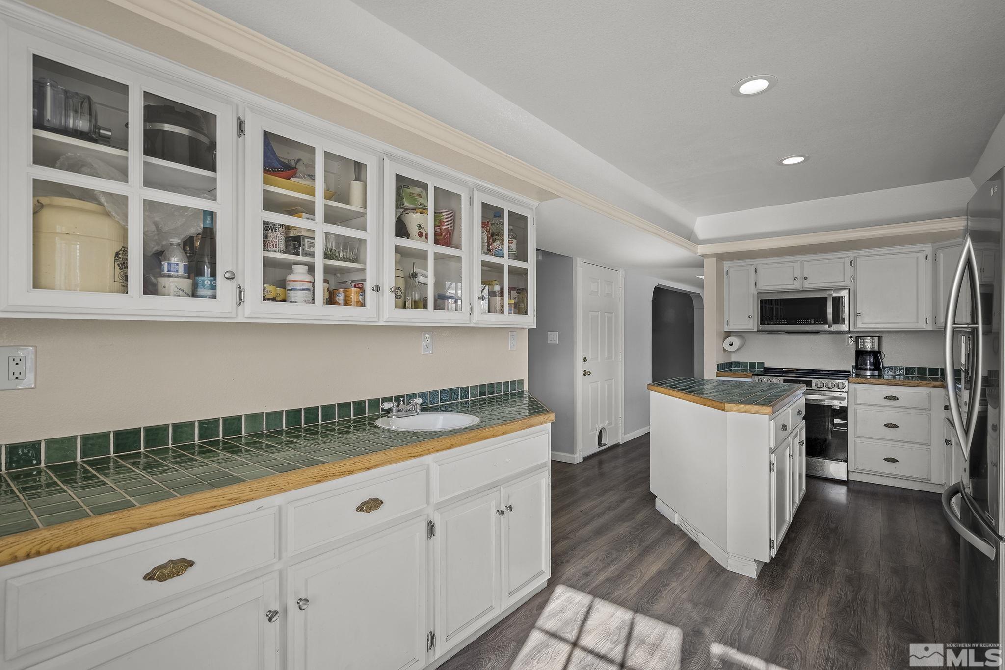 5960 Mallow Road Carson City, NV 89701 - Photo 11 of 34 a kitchen with counter top space cabinets and wooden floor