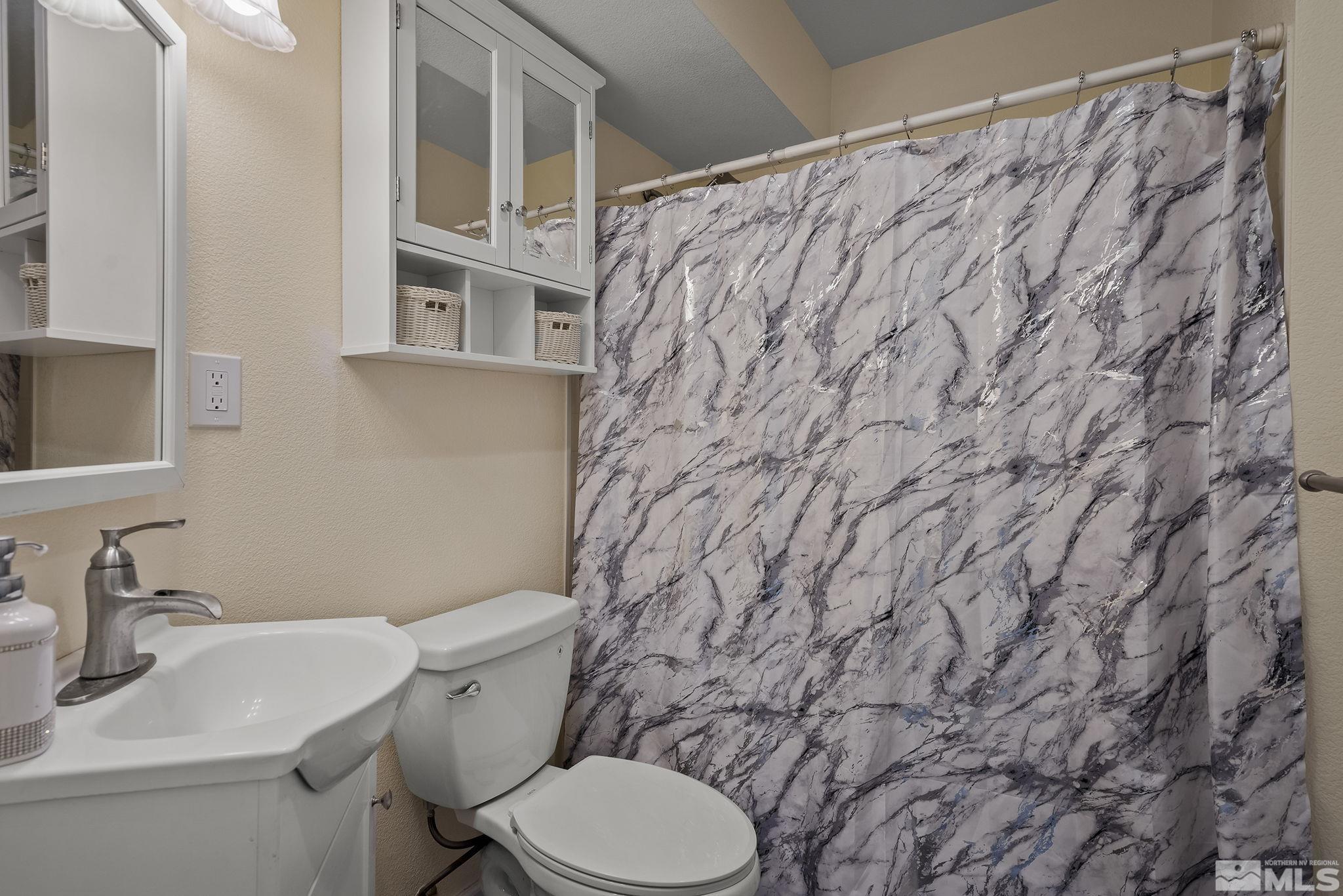 5960 Mallow Road Carson City, NV 89701 - Photo 13 of 34 a white toilet sitting next to a bathroom sink