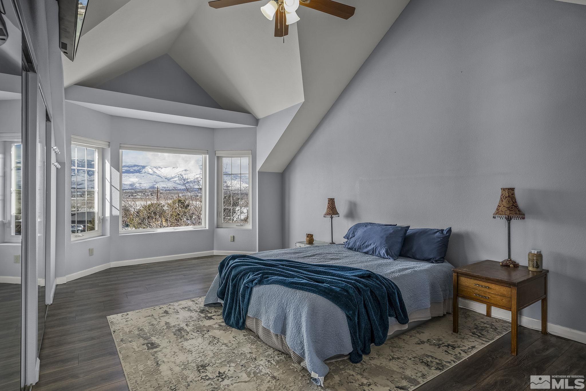 5960 Mallow Road Carson City, NV 89701 - Photo 15 of 34 a bedroom with a large bed and a chandelier