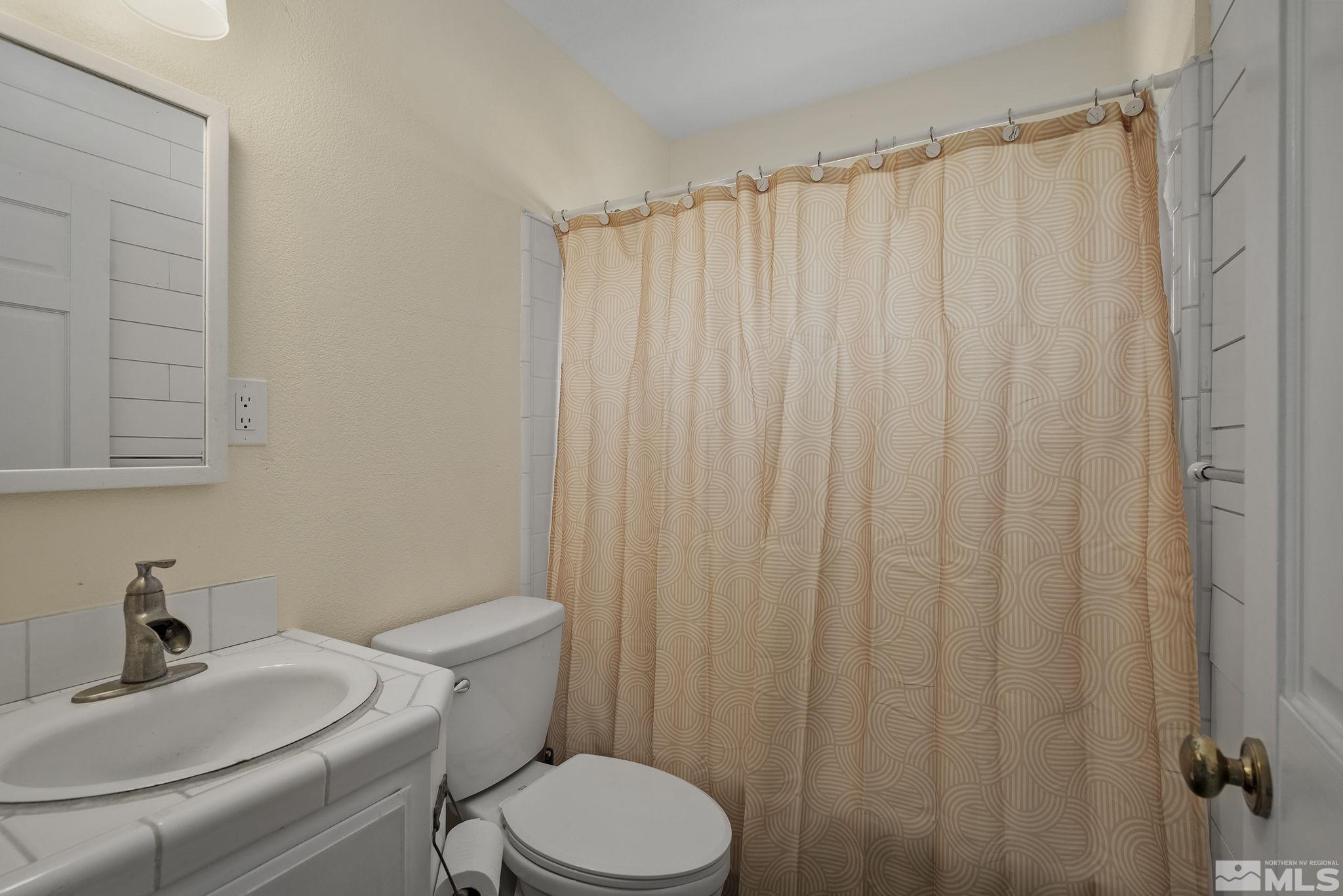 5960 Mallow Road Carson City, NV 89701 - Photo 19 of 34 a white toilet sitting next to a bathroom sink