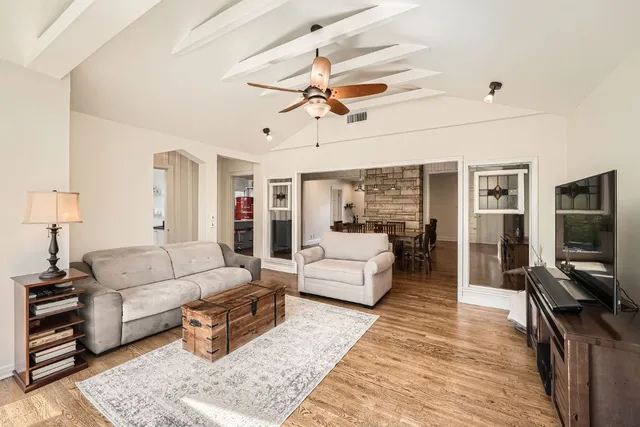 a living room with furniture a flat screen tv and a rug