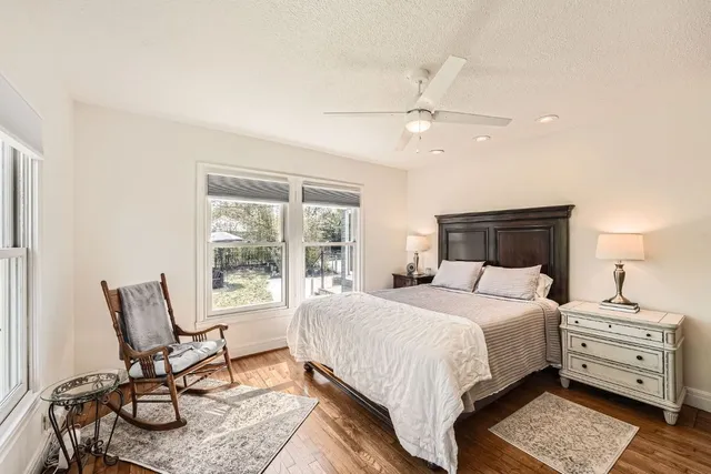 a bedroom with a bed a chair and a large window