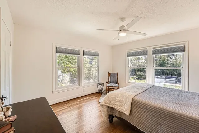 a bedroom with a large bed and wooden floor