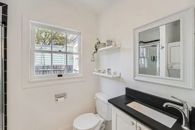 a bathroom with a sink a toilet and a window