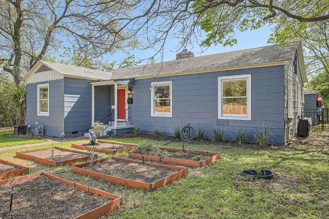a view of a house with backyard and sitting area