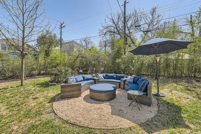 a view of a backyard with table and chairs under an umbrella