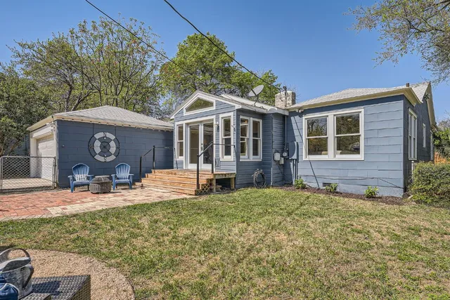 a view of a house with backyard and sitting area