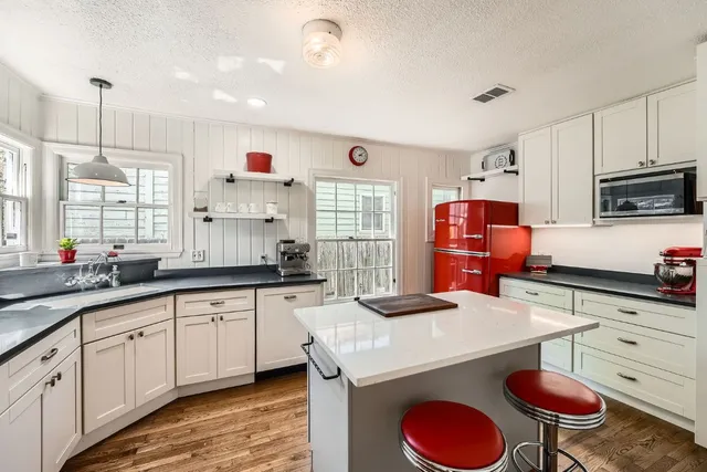 a kitchen with granite countertop a sink appliances cabinets and counter space