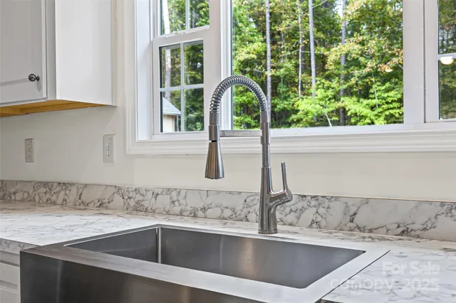 a view of a granite countertop sink and a window