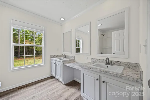 a bathroom with a granite countertop sink mirror and a window
