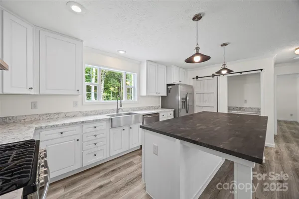 a kitchen with granite countertop a sink a center island and cabinets