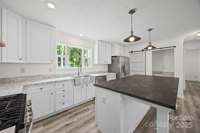 a kitchen with granite countertop a sink a center island and cabinets