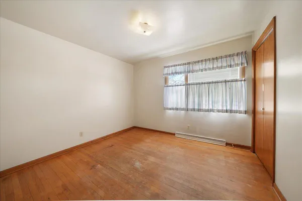 an empty room with windows and closet