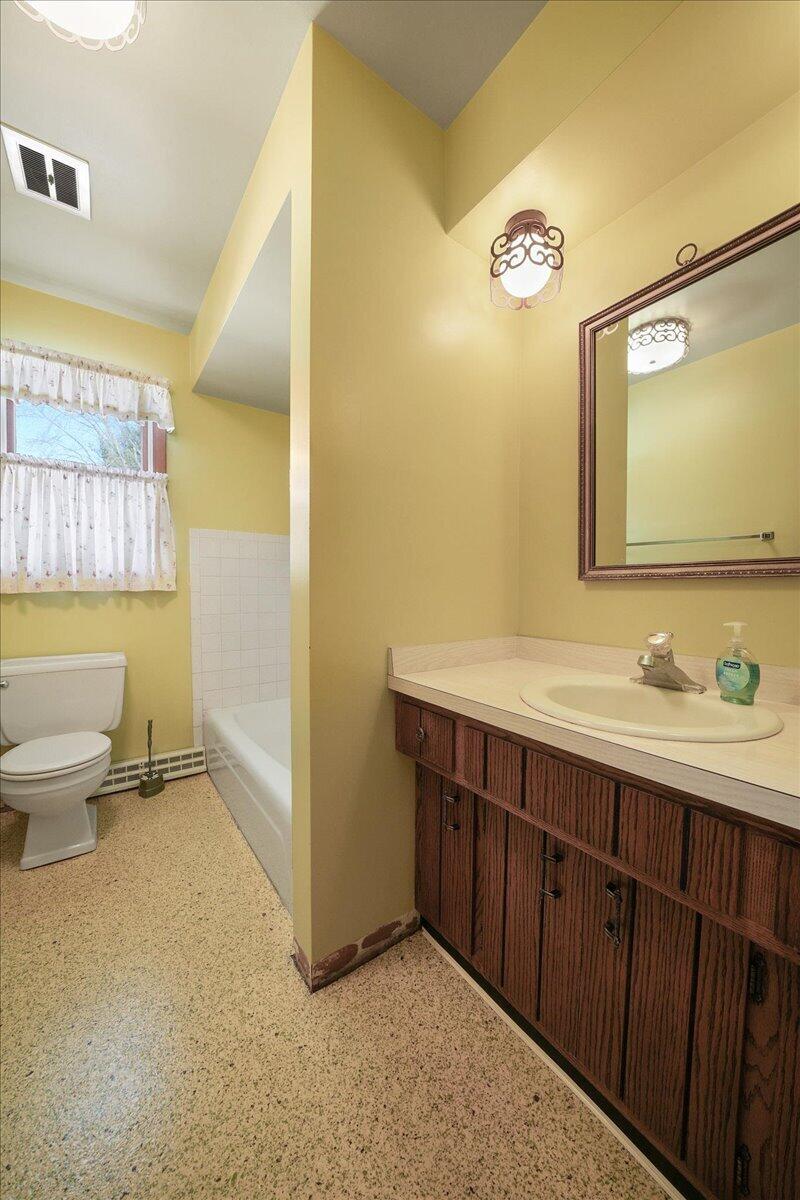 805 West Wilson Street Hebron, IN 46341 - Photo 17 of 27 a bathroom with a sink a toilet and a mirror