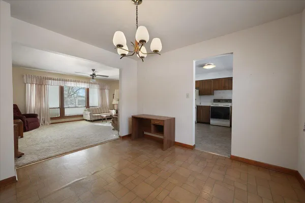 a view of a livingroom with a fireplace a chandelier and windows