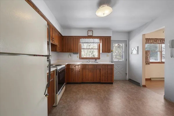 a kitchen with granite countertop a refrigerator and a stove top oven