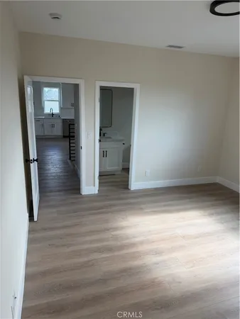 wooden floor in an empty room with a bathroom