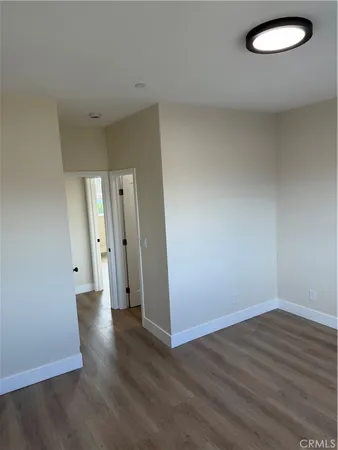 an empty room with wooden floor and mirror