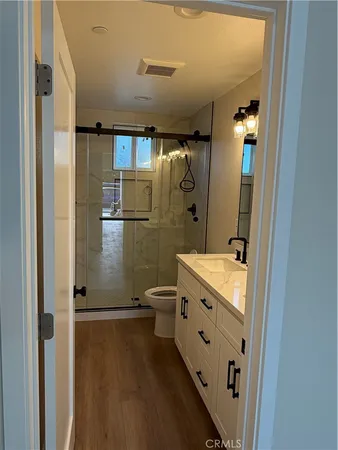 a bathroom with a double vanity sink toilet mirror and shower