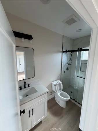 a bathroom with a double vanity sink toilet mirror and shower
