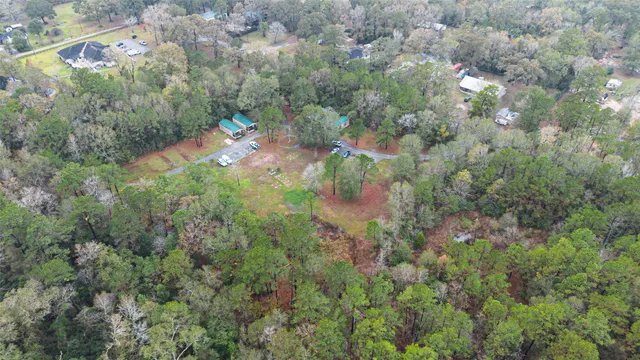an aerial view of residential house with outdoor space and trees all around
