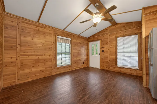 a view of a refrigerator in kitchen and an empty room