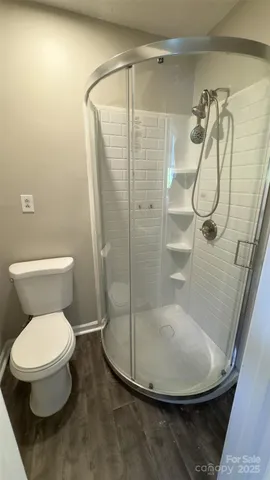 a bathroom with a toilet and a shower
