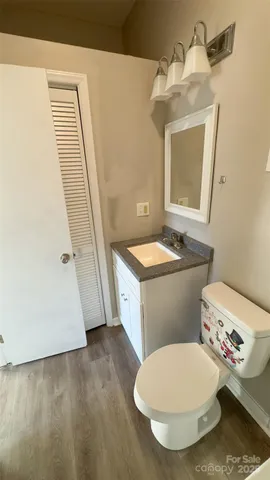 a bathroom with a granite countertop toilet sink and mirror