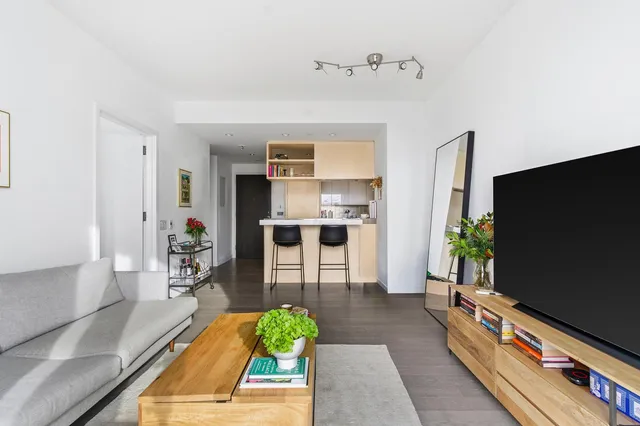 a living room with furniture a flat screen tv and a table