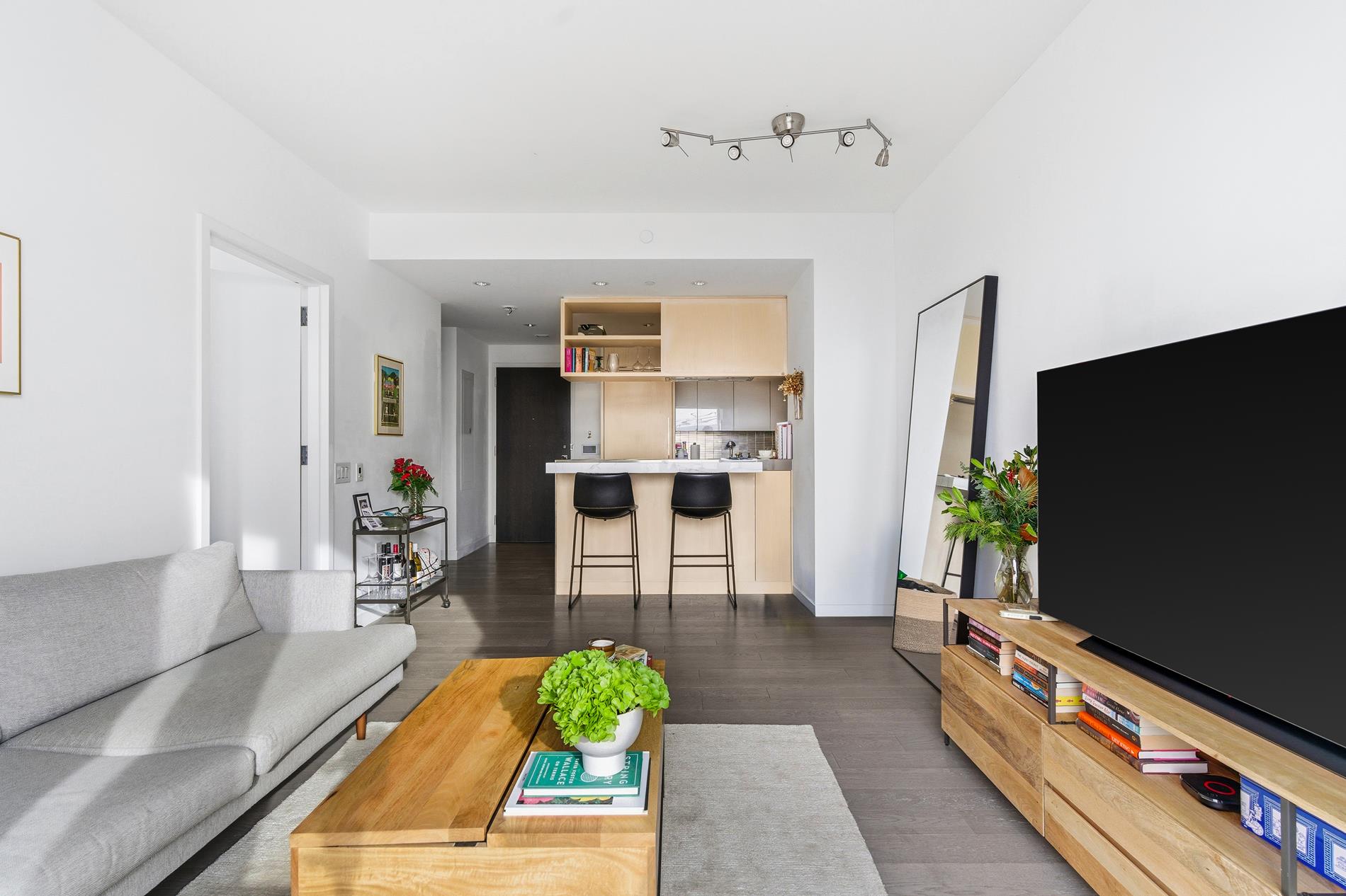 a living room with furniture a flat screen tv and a table