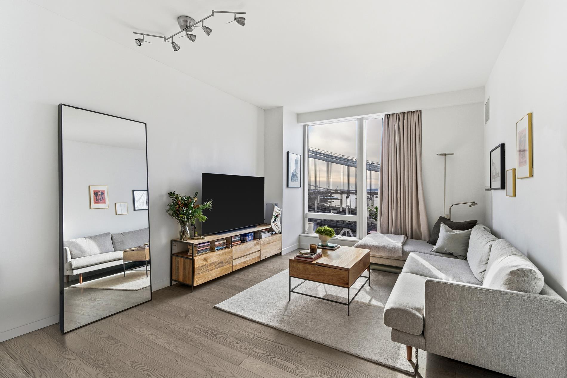 252 South Street, Unit 18B Manhattan, NY 10002 - Photo 4 of 12 a living room with furniture and a flat screen tv
