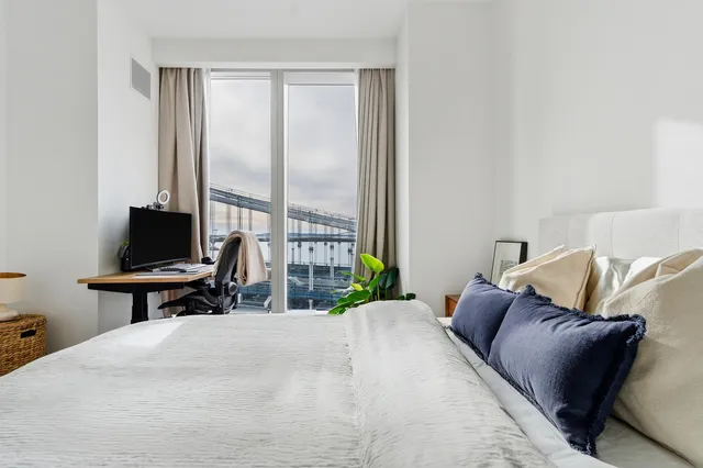 a bedroom with a bed and a potted plant