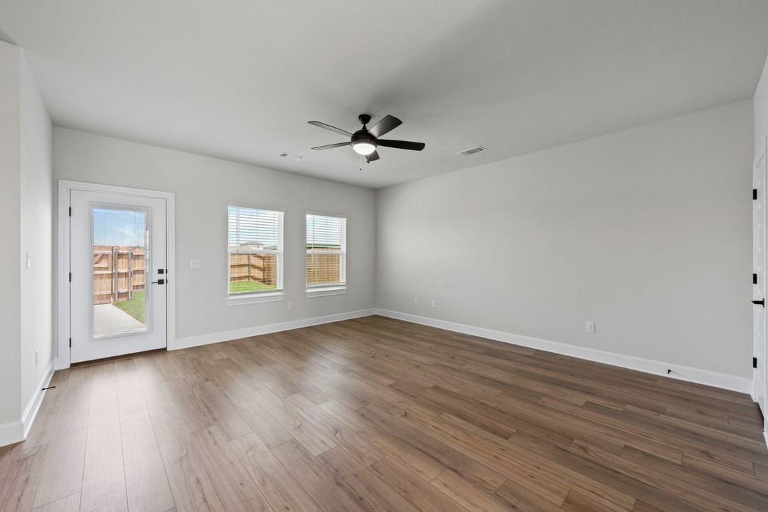 9320 Gladsome Path Manor, TX 78653 - Photo 7 of 18 an empty room with wooden floor and windows