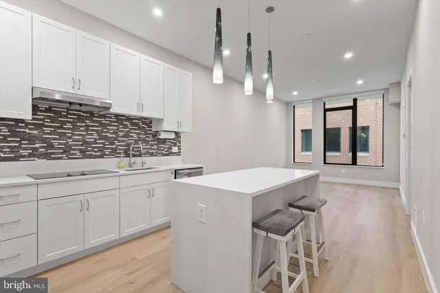 a kitchen with white cabinets and appliances
