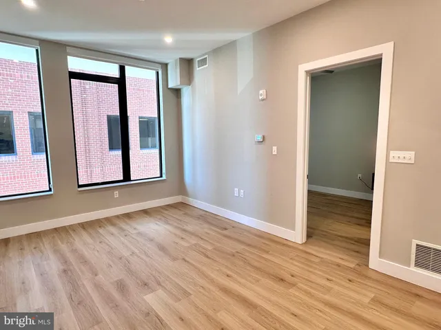 a view of a livingroom with wooden floor and a ceiling fan