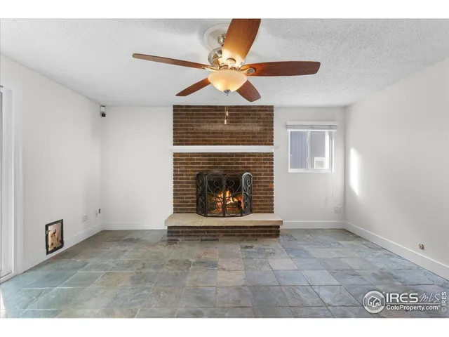 a living room with a fireplace and a ceiling fan