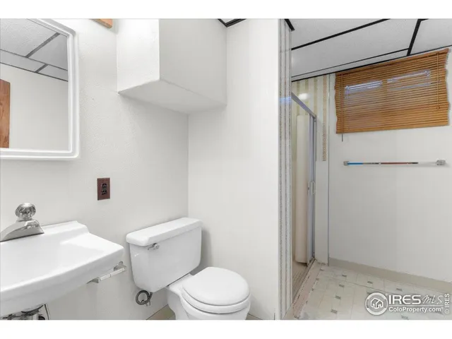 a bathroom with a toilet a sink and a mirror