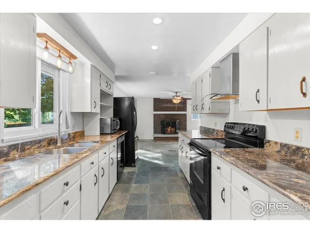 a kitchen with kitchen island granite countertop a sink stove and cabinets