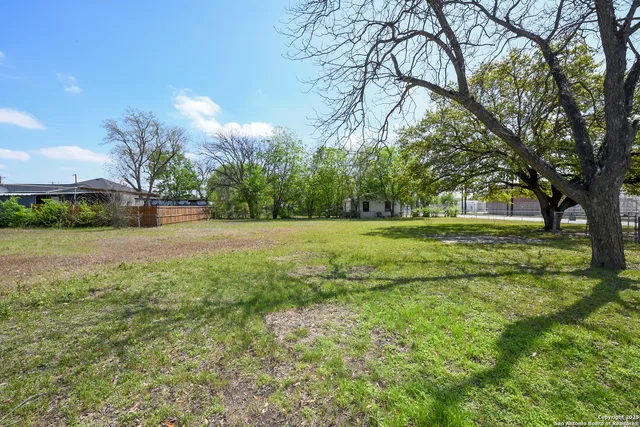 a backyard of a house with lots of green space and fountain