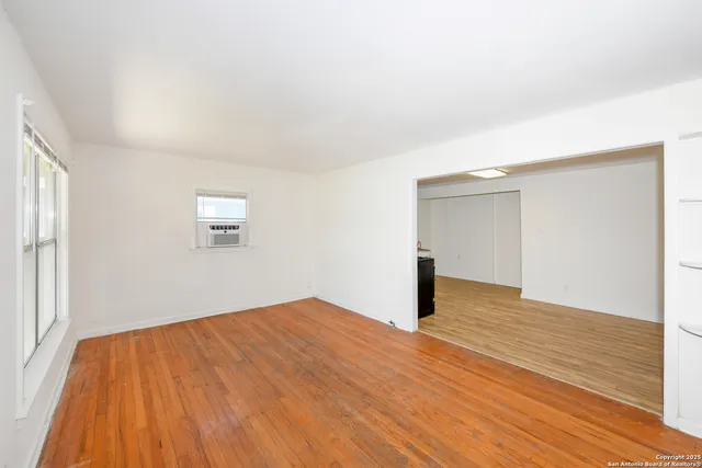 a view of empty room with wooden floor